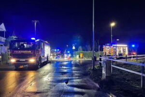 Feuer zerstört zwei Gartenhütten in Dinslaken-Hiesfeld Feuerwehrfahrzeuge löschen Brand von Gartenlauben in Dinslaken-Hiesfeld, umgebene Vegetation betroffen.