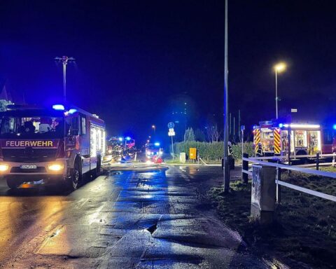 Feuerwehrfahrzeuge löschen Brand von Gartenlauben in Dinslaken-Hiesfeld, umgebene Vegetation betroffen.