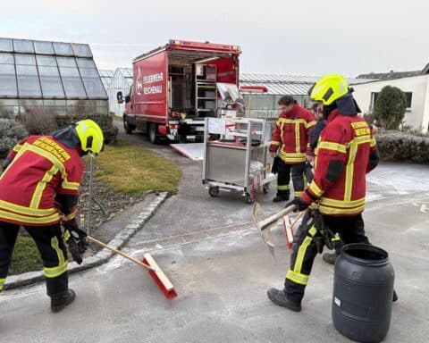 Feuerwehr beseitigt Dieselspur auf Straße in Reichenau: Einsatzkräfte im Action mit Ausrüstung.