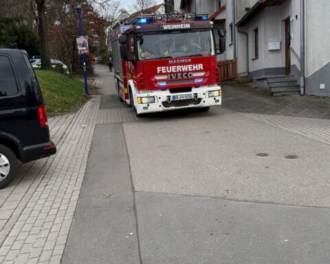Löschfahrzeuge stehen bereit in enger Zufahrtstraße, während Rauchmeldertag gefeiert wird.