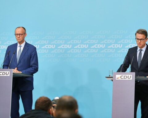 Friedrich Merz und Carsten Linnemann stehen nebeneinander, symbolisieren die CDU und politische Diskussion.