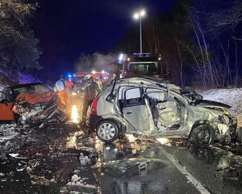 Zwei beschädigte Autos nach schwerem Verkehrsunfall auf Landstraße, verletzte Personen werden behandelt.
