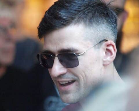 Martin Sellner bei einer politischen Veranstaltung, umgeben von Zuschauern und Rednerpulten.