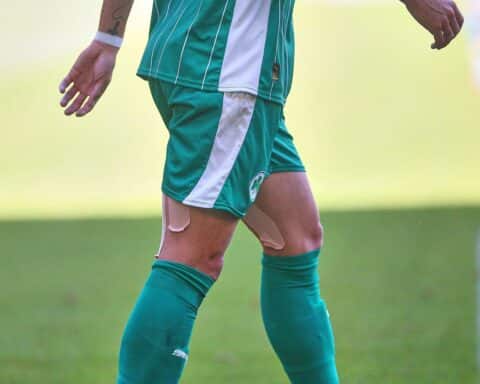 Keyan Varela in Fürth-Trikot, beim Training, umgeben von Mitspielern, Fußballplatz im Hintergrund.