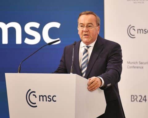 Boris Pistorius im Bundestag, intensives Gespräch über Kampfdrohnen und Sicherheitsfragen.