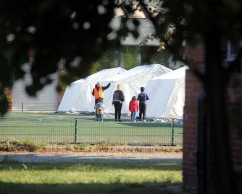 Flüchtlingsfamilie in Zeltstadt, symbolisiert Herausforderungen bei Integrationskurszulassungen und Sprachförderung.