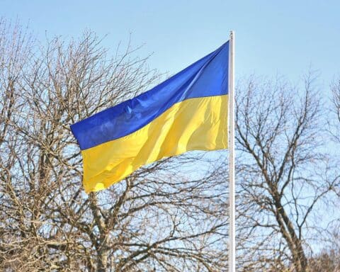 Ukrainische Flagge mit Symbolik der Solidarität und Unterstützung für Geflüchtete und Betroffene.