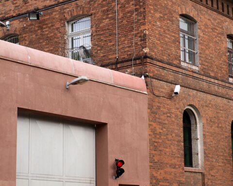 Ein Gefängnis mit hohen Mauern und Stacheldraht, symbolisiert die Justizverwaltung nach einem Verbrechen.