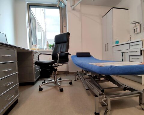 Behandlungszimmer mit Arzt, frustrierten Patienten und elektronischer Patientenakte in der Diskussion.