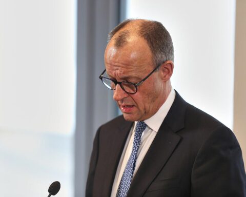 Friedrich Merz steht enttäuscht am Rednerpult, während Wahlumfragen seiner Partei sinken.