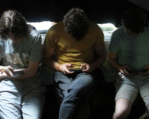 Junge Leute nutzen Smartphones, diskutieren über Social Media, Datenschutz und Jugendschutz.