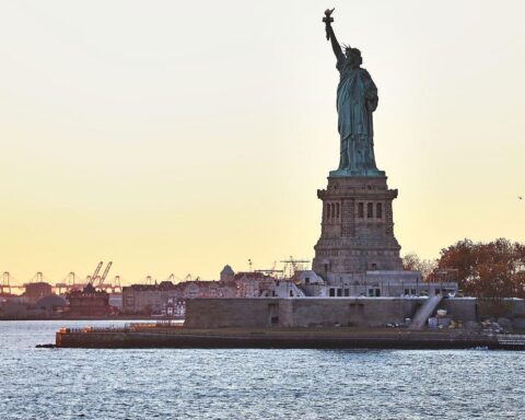 Industrieanlagen, Hafen und Freiheitsstatue symbolisieren Handelskonflikte und wirtschaftliche Dynamik zwischen Europa und den USA.