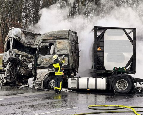 Zwei brennende LKWs auf der Autobahn, Feuerwehr im Einsatz, Unfallstelle mit Chaos.