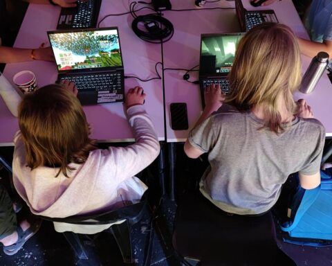 Junge Menschen spielen Videospiele, symbolisieren digitale Kompetenz und das Lernen in der Online-Welt.