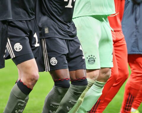 Bayern-Spieler jubeln, während im Hintergrund die DFB-Pokal-Auslosung ansteht. Spannung und Vorfreude spürbar.