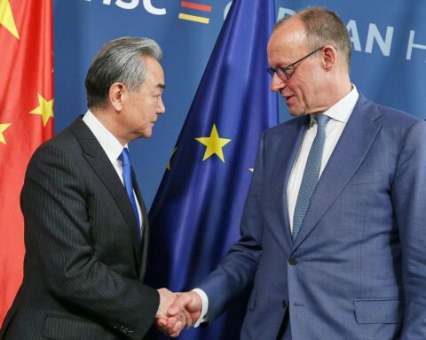 Friedrich Merz und Wang Yi beim diplomatischen Austausch über Frieden und Zusammenarbeit.