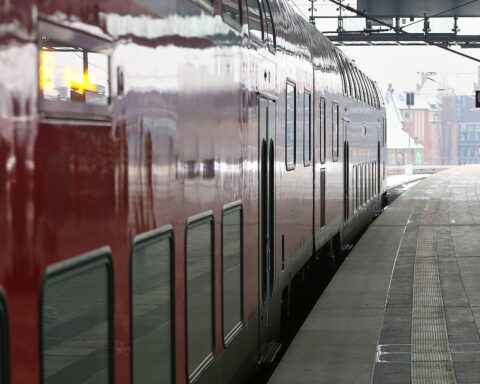 Zug mit Fahrgästen, während Polizei entspannt auf Bahnhof wartet. Vorfall wird untersucht.