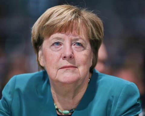 Angela Merkel als Gastpredigerin in der Klosterkirche, umgeben von Mönchen und Orgelmusik.