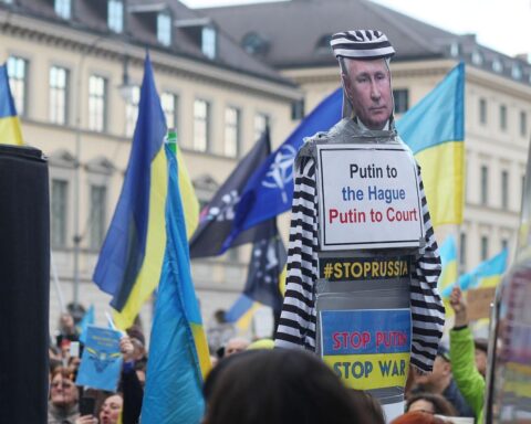 Demonstration für Ukraine mit Menschenmengen, Transparenten und Symbolen des Friedens.