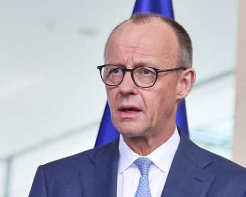 Friedrich Merz am Telefon, symbolisiert Zusammenarbeit zwischen Deutschland und Nigeria.