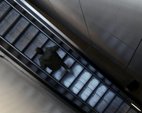 Einem Mann, der eine stille Rolltreppe an einem Bahnhof hinaufgeht, fehlt Mobilität.