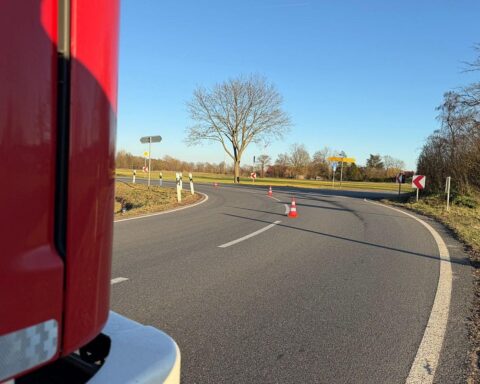 Ölspur auf der Straße mit Feuerwehr, Verkehrsabsicherung und Reinigungseinsatz sichtbar.