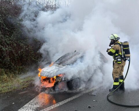 PKW-Brand auf Autobahn mit Feuerwehr im Einsatz zur Brandbekämpfung und Absicherung der Strecke.
