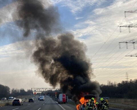 Fahrzeugbrand auf Autobahn 42, Feuerwehr im Einsatz, Rauch und Flammen sichtbar, Verkehrsbehinderungen.