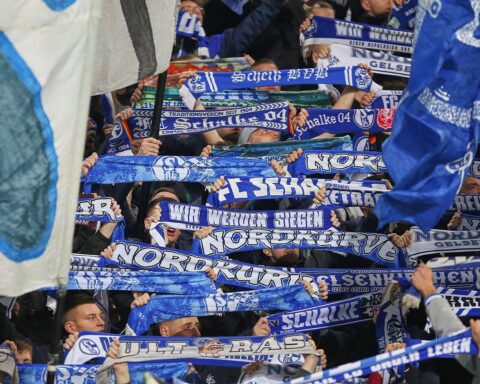 Fans von Schalke 04 jubeln im Stadion, während die Polizei für Sicherheit sorgt.