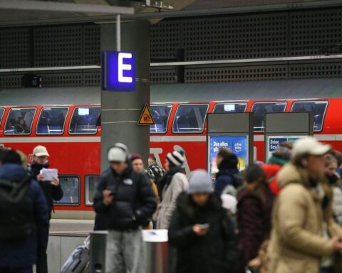 Reisende vor Regionalzug, Symbol für Vorschlag eines einheitlichen Deutschlandtickets mit Lichtbild.