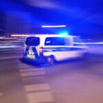 Polizeiauto mit Blaulicht, Zeugen beobachten festgenommenen Mann bei antisemitischer Schmiererei in Berlin.