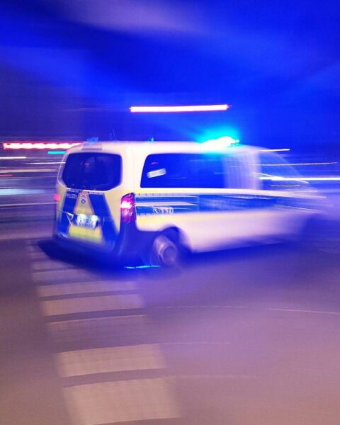 Polizeiauto mit Blaulicht bei Nacht, symbolisiert eine schwere Gewalttat in Krefeld.