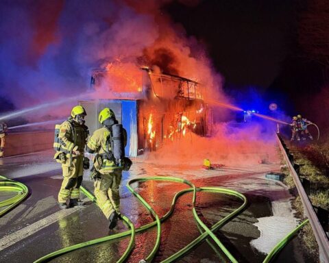 Brennender Reisebus auf Autobahn, Feuerwehr im Einsatz, zahlreiche Rettungskräfte, Autobahn gesperrt.