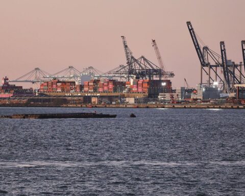 Industrieanlagen mit europäischer Flagge, symbolisieren Handelsbeziehungen und aktuelle Zollkonflikte mit den USA.
