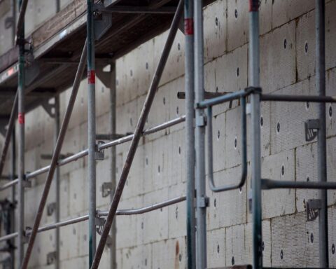 Gerüstbau für Wärmedämmung, symbolisiert Maßnahmen zur Klimaneutralität und energetischer Sanierung.