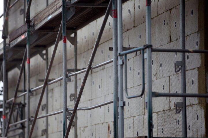 Gerüstbau für Wärmedämmung, symbolisiert Maßnahmen zur Klimaneutralität und energetischer Sanierung.