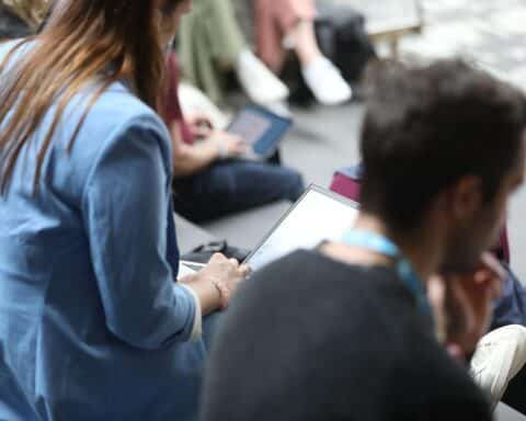 Junge Menschen am Laptop, diskutieren über Arbeit und Zukunftschancen in der Gesellschaft.