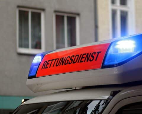 Rettungswagen am Unfallort, geschädigtes Auto, verletzte Personen, Polizei bei den Ermittlungen.