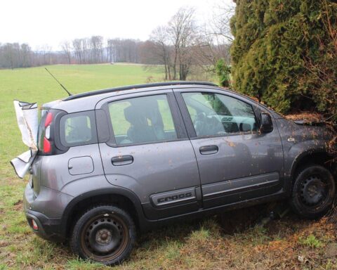 Verunfallter Fiat nach Crash gegen Strommast; Fahrer in Lebensgefahr, Erste Hilfe geleistet.