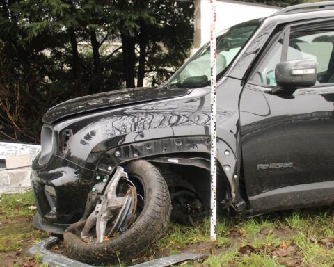 Verunfallter Jeep zwischen Mauer und Baum, Feuerwehr befreit eingeklemmten Fahrer, Unfallstelle gesperrt.