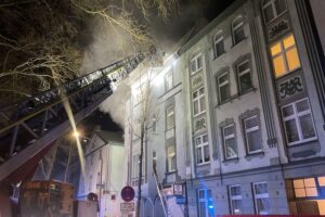 Drehleitern der Feuerwehr retten Bewohner aus brennendem Mehrfamilienhaus in Dortmund.