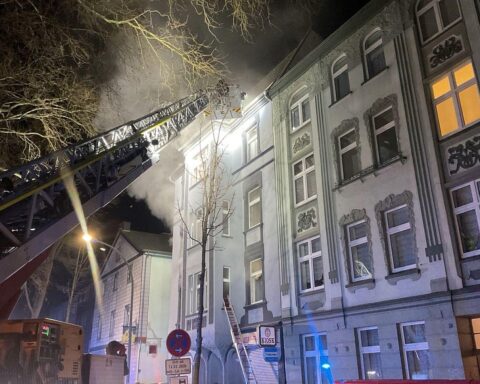 Drehleitern der Feuerwehr retten Bewohner aus brennendem Mehrfamilienhaus in Dortmund.