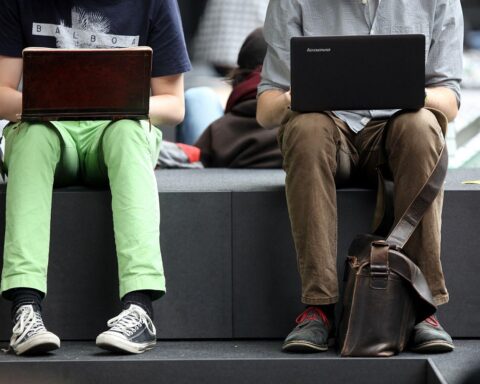 Zwei Männer surfen online, während Sicherheitsexperte vor Risiken der KI-Anwendung "OpenClaw" warnt.