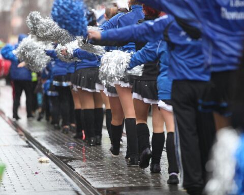 Tanzmariechen in bunten Kostümen feiern ausgelassen im Kölner Straßenkarneval mit fröhlicher Stimmung.