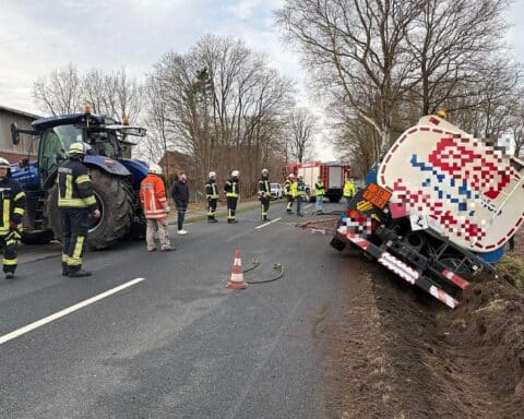 Tankwagen im Graben, Feuerwehr und Polizei sichern Unfallstelle, Straße gesperrt.