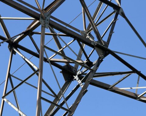 Strommast vor blauem Himmel symbolisiert Deutschlands Energieinfrastruktur und den staatlichen Einstieg bei Tennet.