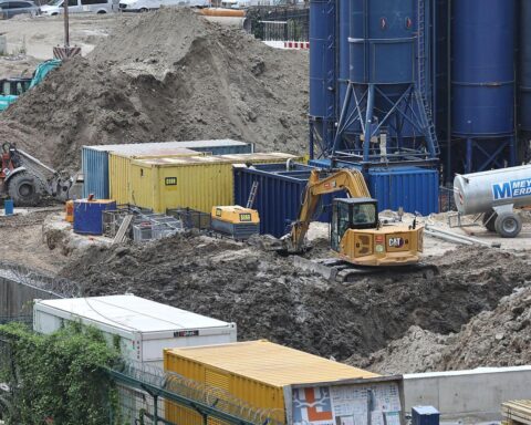 Baustelle mit Baufahrzeugen und Arbeitern, symbolisiert Wachstum und Herausforderungen im Thüringer Baugewerbe.