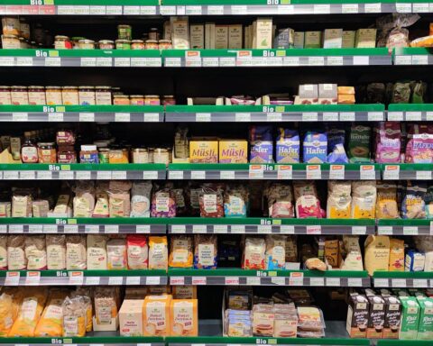 Supermarktregal mit Bio-Produkten und Preisschildern, symbolisiert steigende Verbraucherpreise.