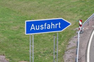 Schild einer Autobahn, Unfallstelle, Nebel, Rettungsfahrzeuge und Unfallopfer im Hintergrund.