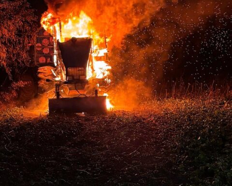 Brennender Traktor auf Feld, Feuerwehr löscht Flammen, Sicherheit der Anwohner gewährleistet.